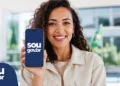 Mulher segura celular com o SOUGOV.BR durante etapa de posse digital de candidatos nomeados no CPNU.