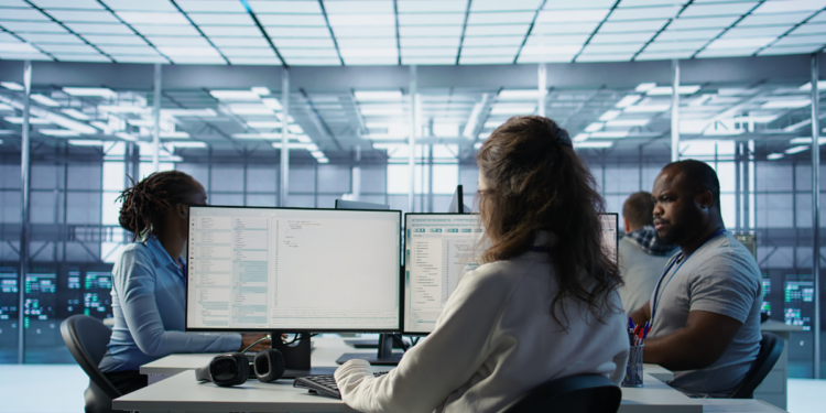 Profissionais de TI monitoram sistemas em ambiente de datacenter.