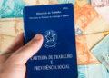 Carteira de Trabalho e notas de real simbolizam emprego e salário no Brasil.