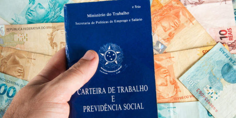 Carteira de Trabalho e notas de real simbolizam emprego e salário no Brasil.