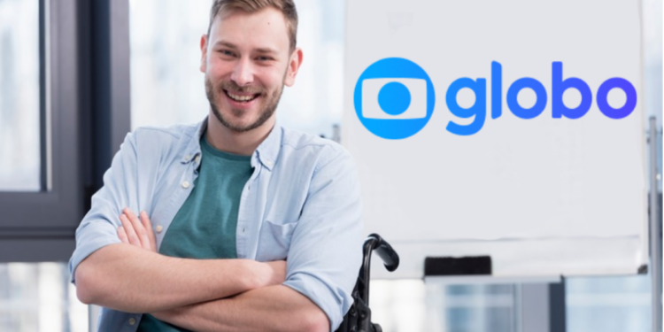 Jovem cadeirante sorridente em ambiente corporativo com logotipo da Globo ao fundo.