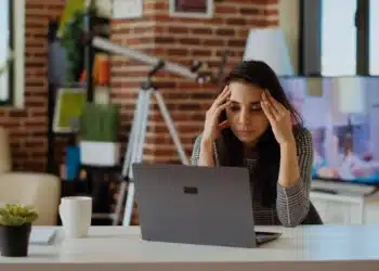 Profissional demonstra cansaço durante atividade de trabalho diante do computador.