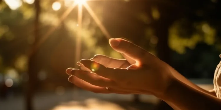 Mãos abertas em direção à luz do sol, simbolizando bênçãos, fé e gratidão.