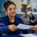Jovem entregando apostila, representando a participação no programa gratuito de qualificação profissional com bolsa oferecida pela Petrobras.