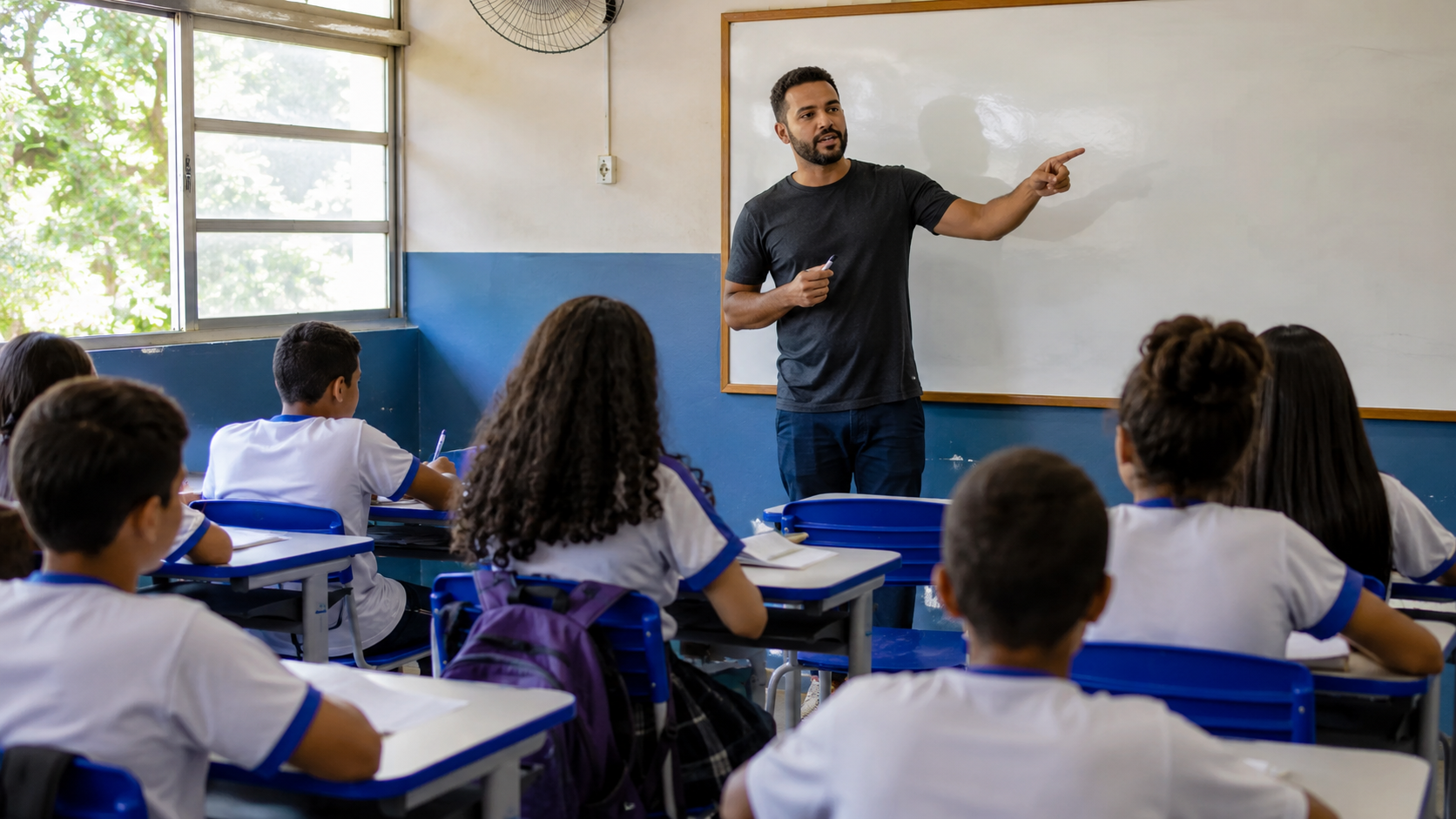 Professor da educação básica dá aula em escola pública para alunos em sala de aula.