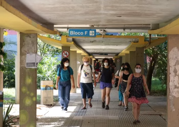 Imagem ilustrativa de estudantes caminhando por passarela coberta em campus universitário, em referência aos próximos passos do vestibular Fuvest 2027