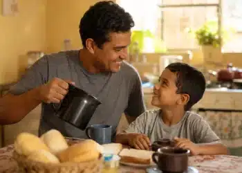 Pai e filho compartilham um café da manhã simples, representando uma comemoração econômica do Dia dos Pais.