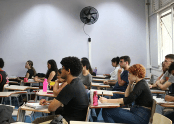 Estudantes em sala de aula realizando preparação para concurso público durante período eleitoral.