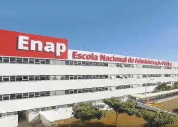 Fachada do prédio da Enap, a Escola Nacional de Administração Pública, em Brasília, com o letreiro vermelho e branco sob céu azul, instituição ligada à organização do concurso nacional