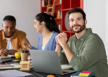 Coordenador pedagógico analisando materiais educacionais em ambiente escolar.