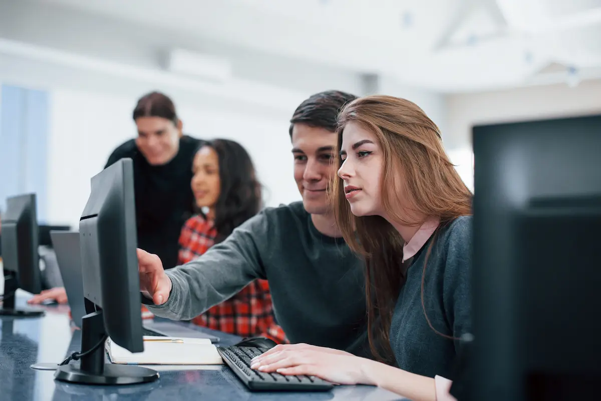 Estudantes utilizam computadores durante formação prática voltada para o mercado de trabalho.