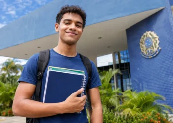 Estudante com mochila e cadernos em frente a uma universidade federal, representando os cursos de graduação autorizados pelo MEC em quatro universidades federais.