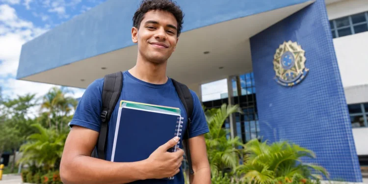 Estudante com mochila e cadernos em frente a uma universidade federal, representando os cursos de graduação autorizados pelo MEC em quatro universidades federais.