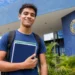 Estudante com mochila e cadernos em frente a uma universidade federal, representando os cursos de graduação autorizados pelo MEC em quatro universidades federais.