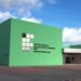 Fachada verde de um campus do Instituto Federal da Bahia, com bandeiras do Brasil e do estado hasteadas na entrada, em referência às unidades que recebem as vagas.