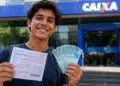 Estudante segurando documento e notas de real em frente a uma agência da Caixa, representando o desconto na dívida do Fies pelo programa Desenrola Adimplentes.