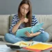 Estudante revisa conteúdos em casa com caderno e notebook durante rotina de estudos.