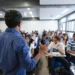 Professor ministra aula para estudantes em sala, em referência ao Dia dos Profissionais da Educação.