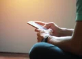 Pessoa acessa informações pelo celular, representando consulta ao cartão de confirmação do Encceja 2026.