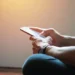 Pessoa acessa informações pelo celular, representando consulta ao cartão de confirmação do Encceja 2026.
