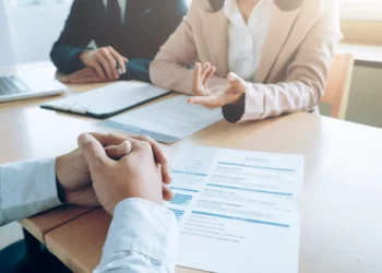 Candidato participa de entrevista de emprego e conversa sobre pretensão salarial com recrutadores.