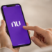 Pessoa acessa aplicativo do Nubank pelo celular, representando vagas de estágio na área de inteligência artificial.