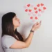 Mulher soprando corações para representar a expressão “eu te amo” na língua portuguesa.