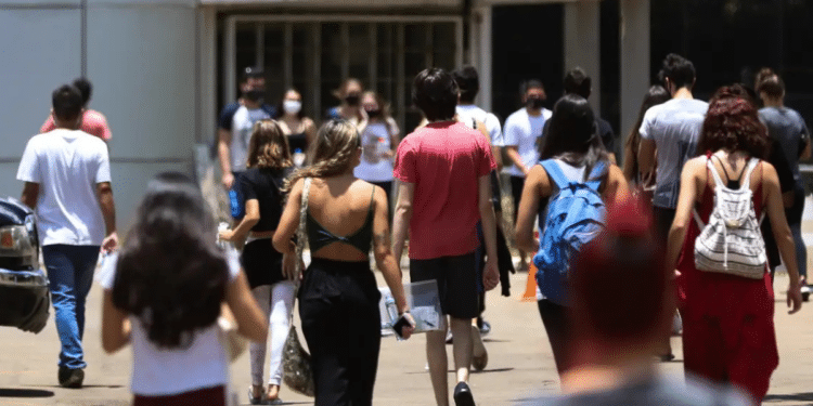 Estudantes universitários em ambiente acadêmico representando escolhas entre segunda graduação e pós-graduação.