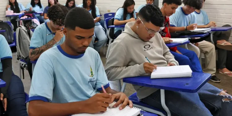 Imagem ilustrativa de estudantes do ensino médio realizando atividades em uma sala de aula.