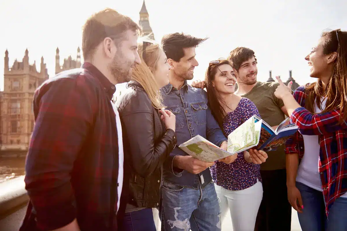 Grupo de estudantes realizando intercâmbio universitário em frente a ponto turístico internacional.
