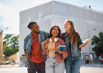 Estudantes universitários participam de intercâmbio acadêmico com livros e materiais de estudo em ambiente universitário.