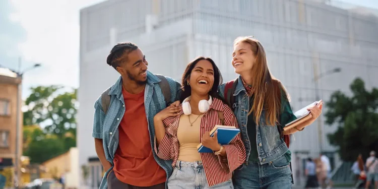 Estudantes universitários participam de intercâmbio acadêmico com livros e materiais de estudo em ambiente universitário.