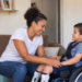 Mãe cuida do filho com deficiência em casa, representando mães atípicas.