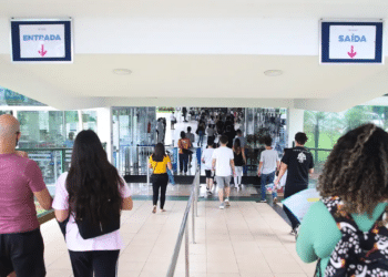 Estudantes com mochilas caminhando em direção à entrada de um prédio de campus universitário, em imagem ligada à ampliação de vagas nas universidades federais.