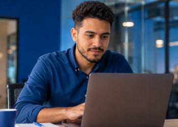 Profissional utiliza notebook em escritório enquanto mantém perfil ativo no LinkedIn.
