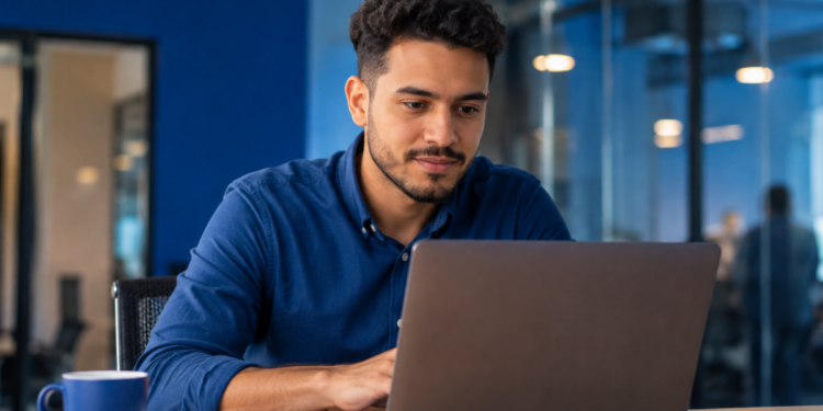 Profissional utiliza notebook em escritório enquanto mantém perfil ativo no LinkedIn.