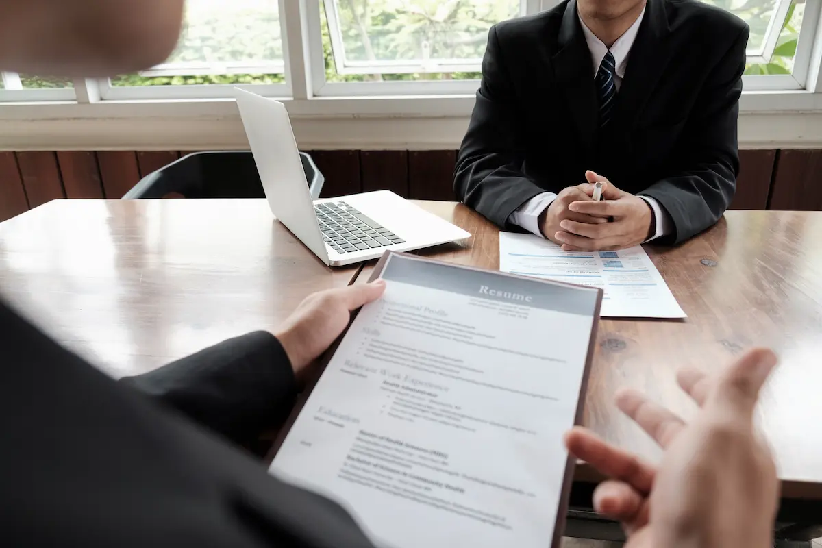 Currículo analisado em entrevista de emprego para avaliar qualificações profissionais.