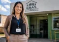 Assistente social em frente a uma unidade do CRAS, Centro de Referência de Assistência Social.
