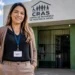 Assistente social em frente a uma unidade do CRAS, Centro de Referência de Assistência Social.