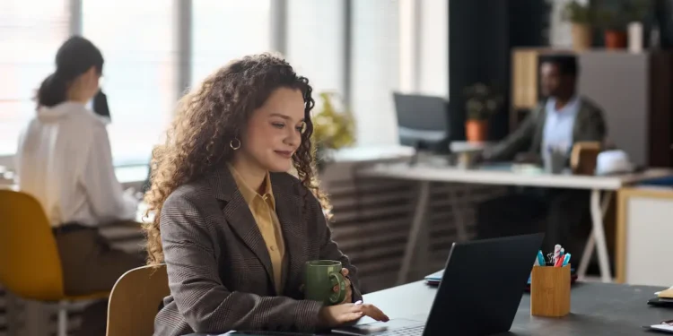 Profissional estudando em escritório com notebook, representando a requalificação profissional e a mudança de carreira após os 30 anos.
