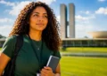 Jovem estudante com mochila em frente ao Congresso Nacional representando projeto de reserva de vagas para jovens no primeiro emprego no setor público.