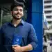 Homem segurando carteira de trabalho em frente a prédio comercial representa o avanço do mercado de trabalho brasileiro.