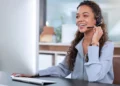 Profissional de televendas utilizando headset durante atendimento por telefone em ambiente de trabalho.