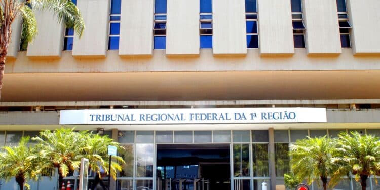 Fachada do prédio do Tribunal Regional Federal da 1ª Região, com o letreiro azul na entrada, palmeiras e escadaria de acesso, referência à decisão da Justiça Federal que suspendeu as punições do órgão de educação