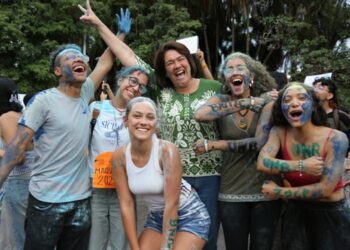 Grupo de estudantes calouros da UnB comemorando ao ar livre, cobertos de tinta azul, em referência à mudança na regra de ingresso na graduação que amplia o uso do Sisu