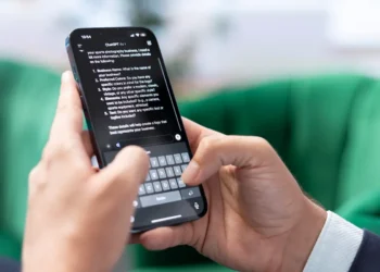 Pessoa utilizando o ChatGPT pelo celular durante debate sobre o uso da vírgula em mensagens digitais.