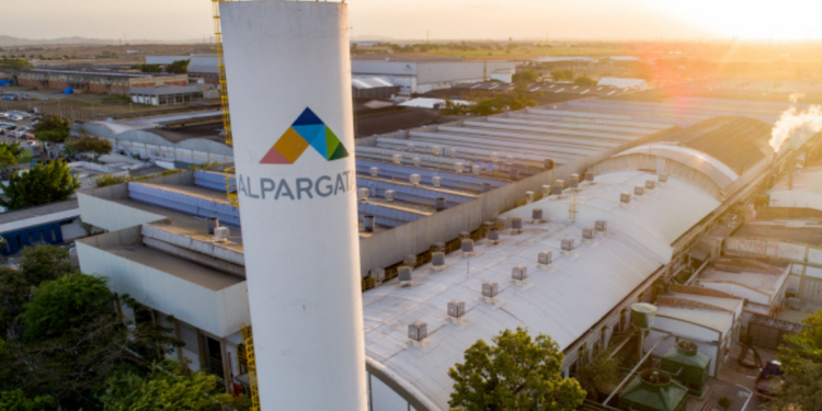 Vista aérea da fábrica da Alpargatas com identificação da empresa em unidade industrial.