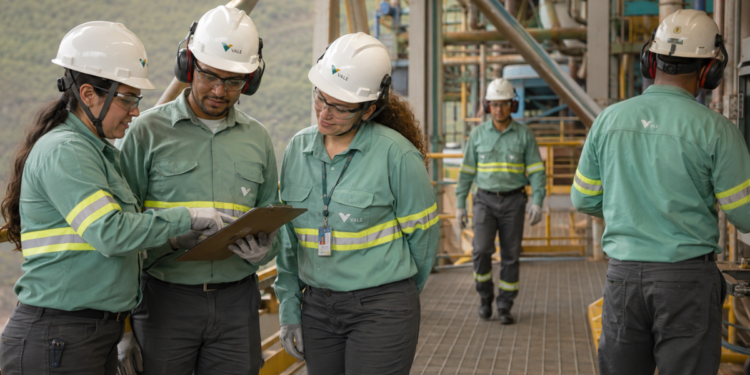Trabalhadores uniformizados atuam em ambiente industrial da Vale, representando a abertura de 450 vagas de estágio técnico.