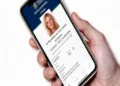Pessoa segurando celular exibindo tela de e-Título da Justiça Eleitoral com foto de mulher, simbolizando o prazo para acesso do app para a eleição de 2026.