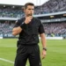Árbitro esportivo de futebol em campo durante partida, representando a atuação dos profissionais da arbitragem e o cumprimento das regras do jogo.